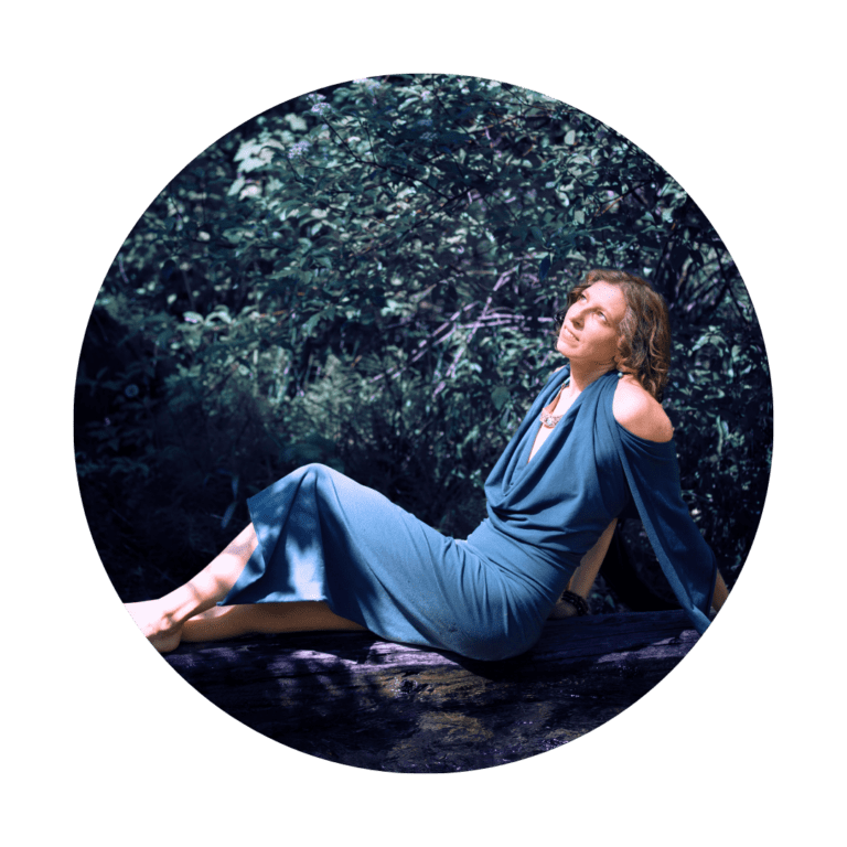 spiritual woman sitting on a log covered in shadows