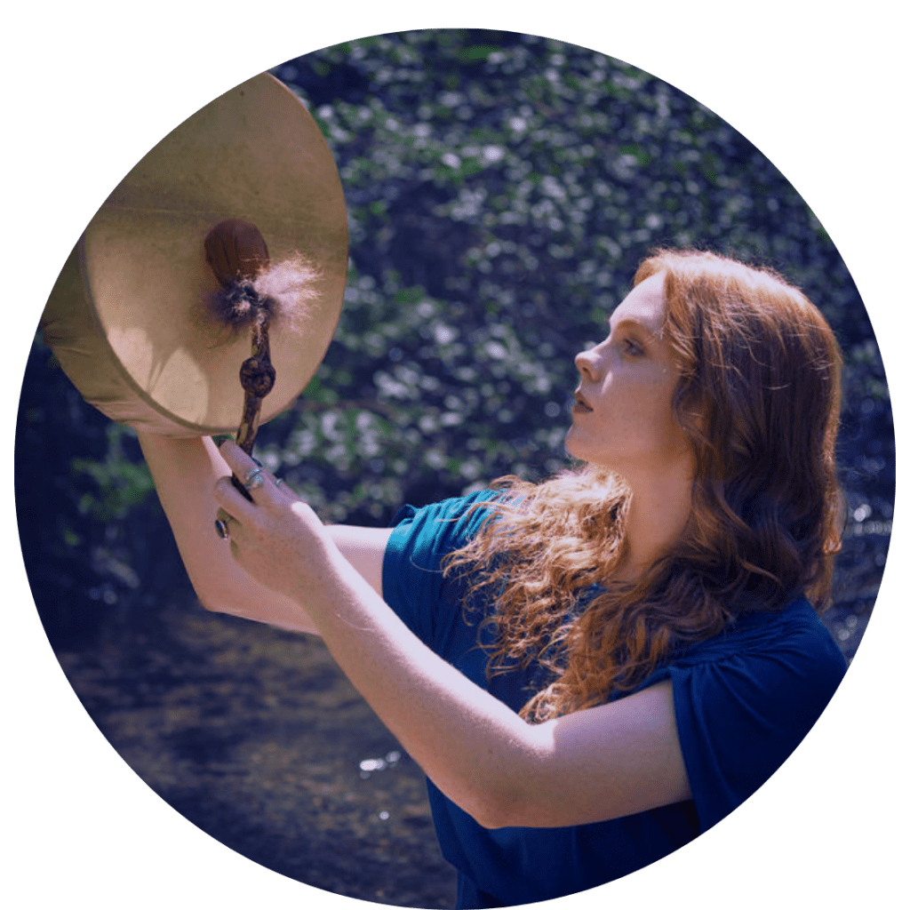 spiritual woman with a shamanic drum in the forest