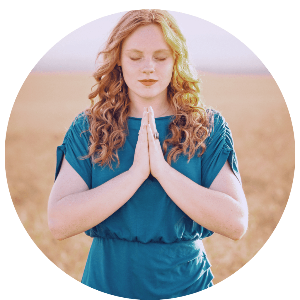 spiritual woman with hands in reiki prayer pose at heart chakra