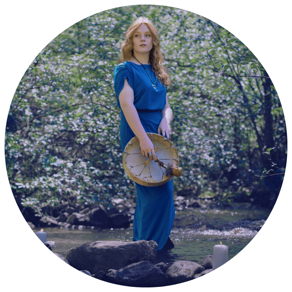 spiritual woman standing with a healing drum in the river