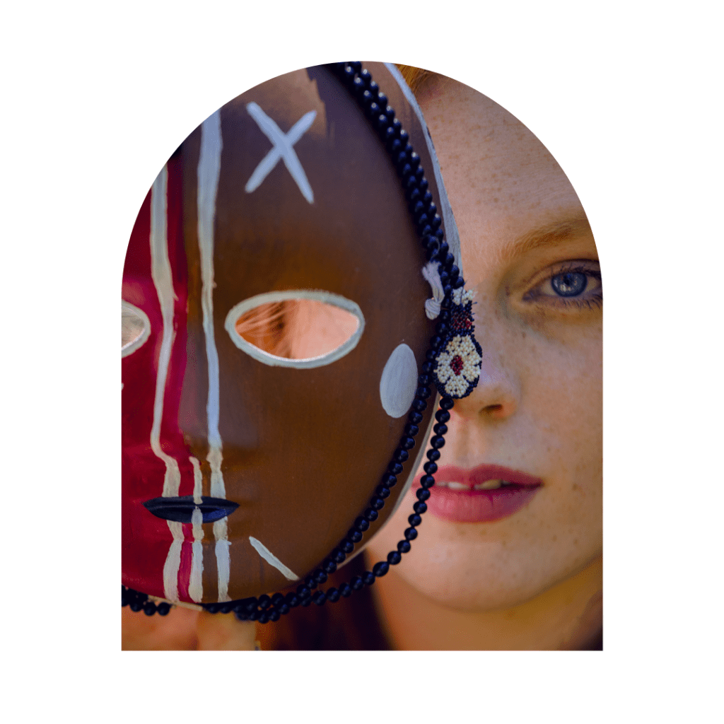 woman holding a shamanic healing mask over her face