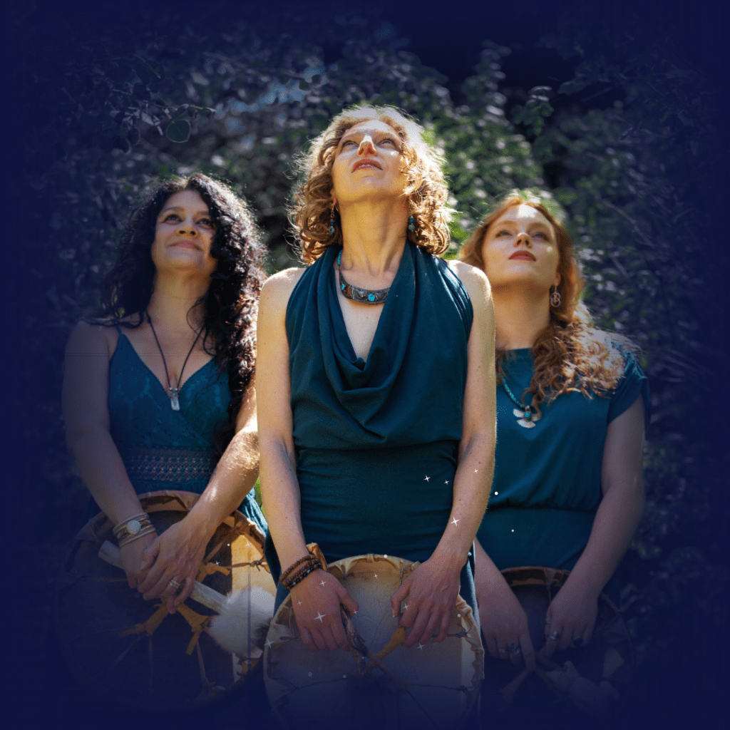 three spiritual women holding shamanic drums looking up at the sky