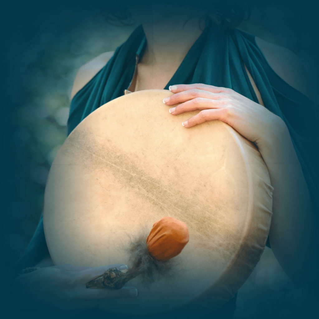 woman holding a shamanic drum and orange drum beater