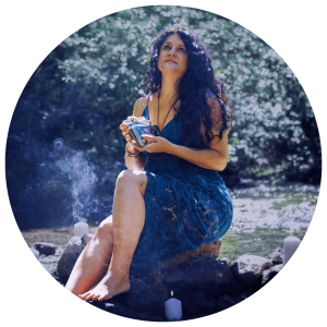 spiritual shamanic woman holding a deck of tarot cards in the middle of a river